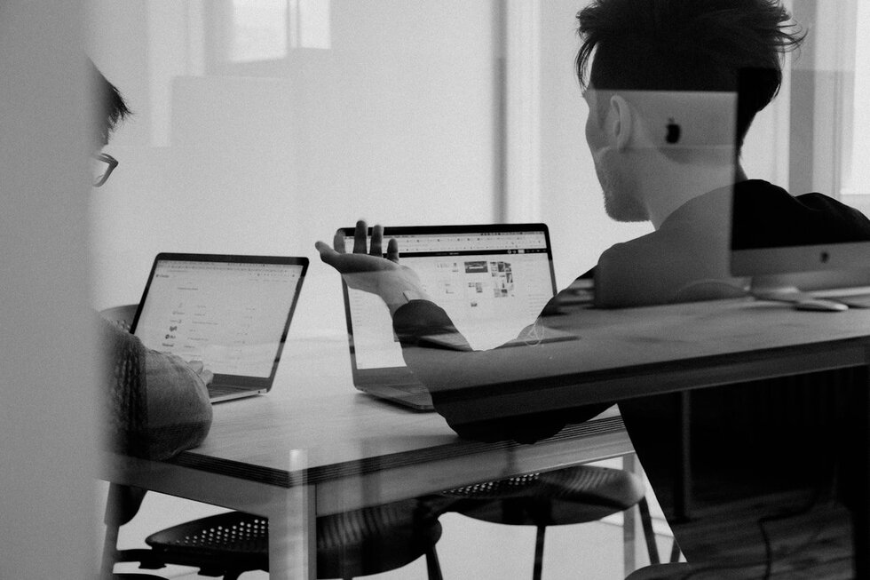 Personen im Gespräch am Laptop